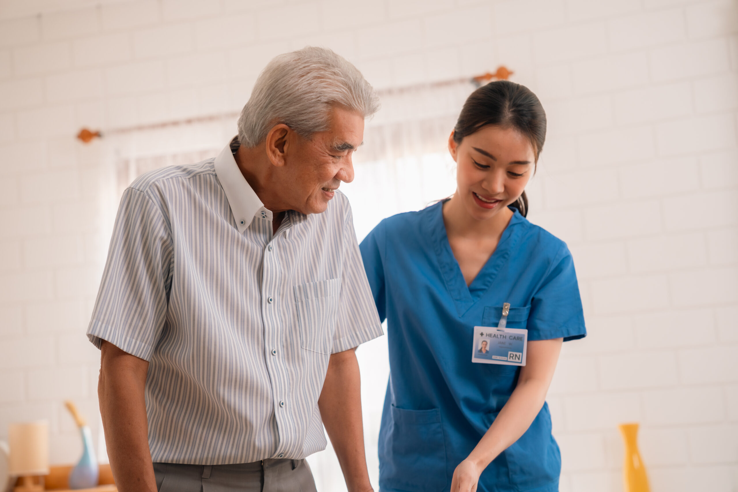 nursing home assistance in health insurance business, asian woman doctor or nurse caregiver Senior Man Receives Medical Check-Up Therapy from Doctor in Hospital Clinic: Professional Health Care Service for Elderly Patients Facing Health Problems, with Comprehensive Exams and Consultations